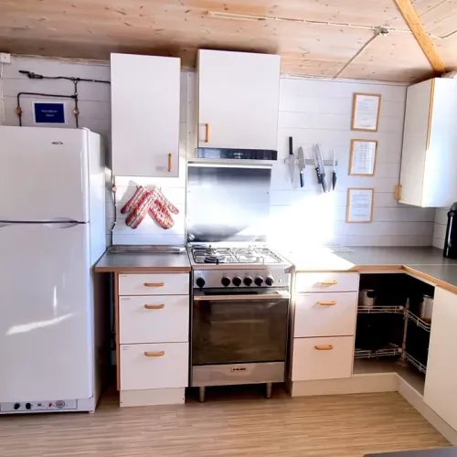 Vitt kök med gasolspis och kylskåp