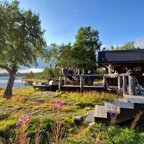 Sällskap på altan vid sjön i kvällssol