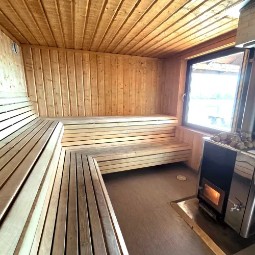 Bastu med träbänkar och vedeldad kamin