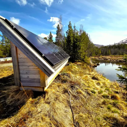 Liten solpanelbod vid myrtjärn i fjällterräng