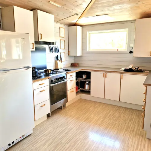 Kök med vita skåp och gasolspis