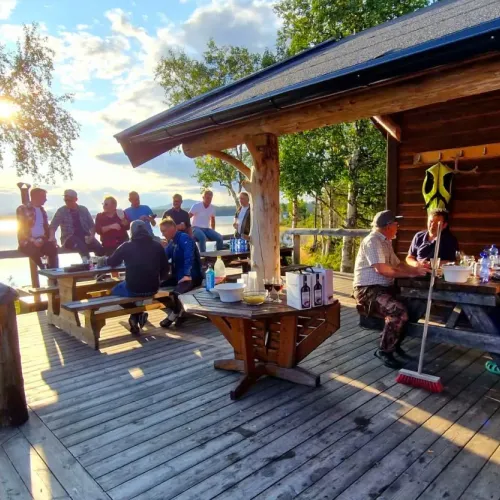 Sällskap vid bord på altan i kvällsljus