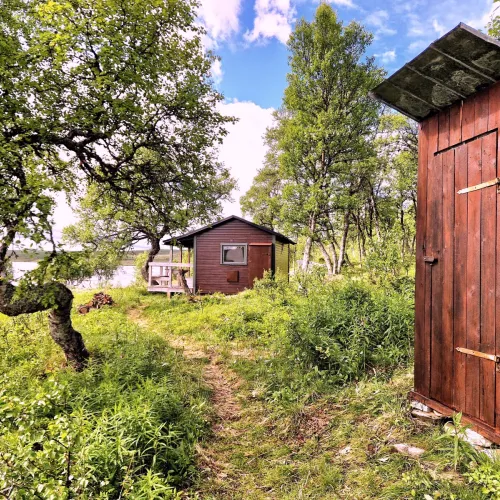 Utedass med stuga och sjöutsikt i bakgrunden