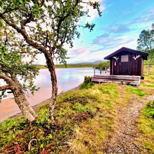Bastubyggnad med hornprydnad vid sjökanten