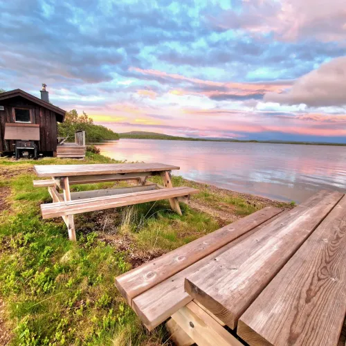 Picknickbord vid stranden i solnedgång