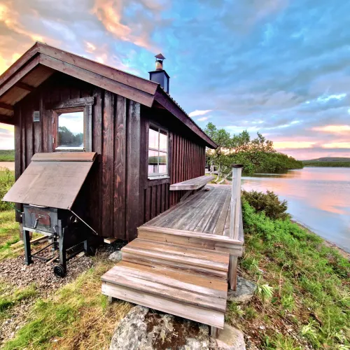 Vedeldad bastu med grill och skorstensplåt vid vattnet