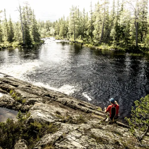 Fiskare sedd uppifrån vid klippig strand