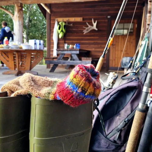 Fiskeutrustning och stövlar på stugans veranda