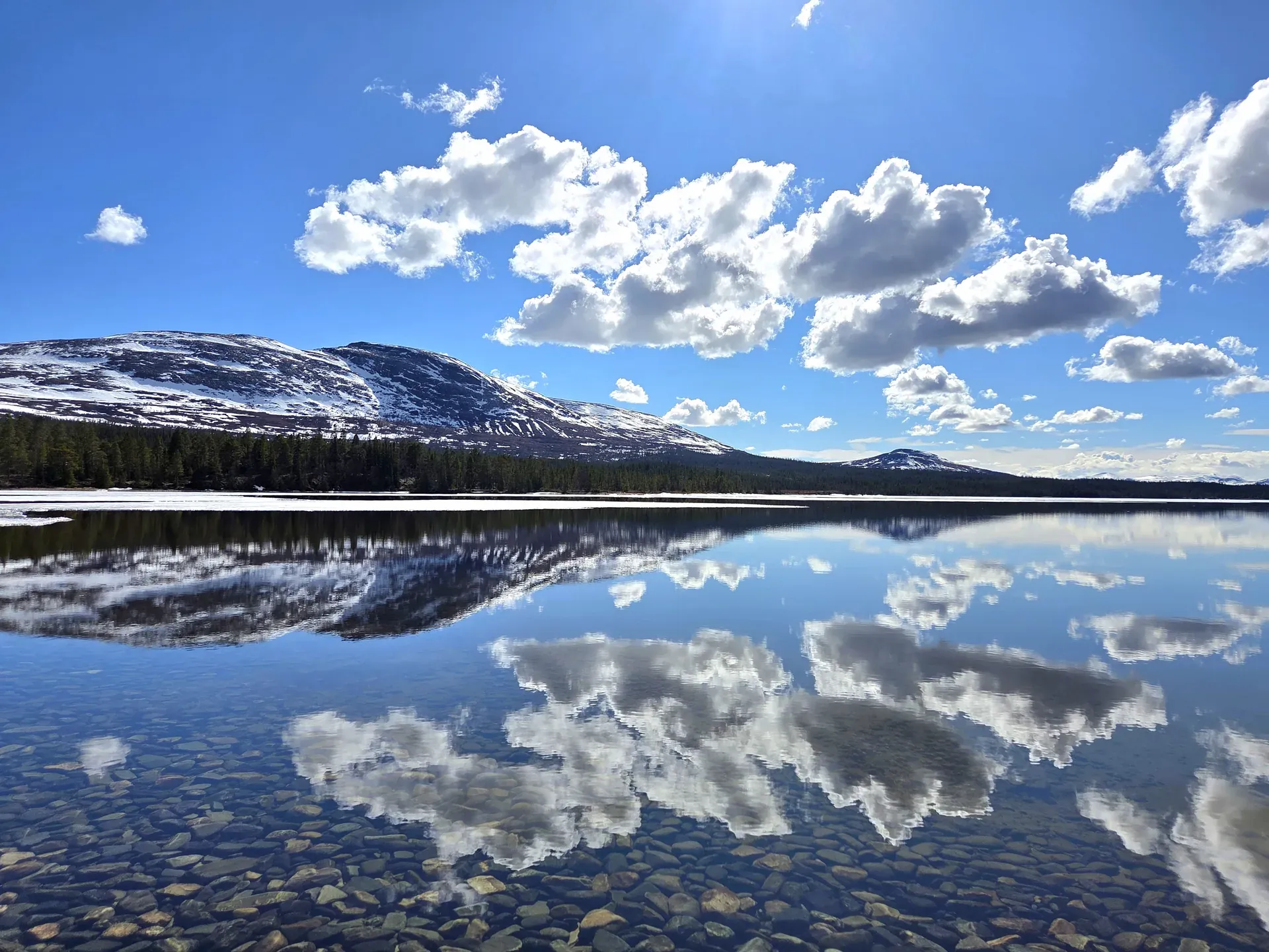 Fjällvy med sjöreflektion över Anarisets fjälllandskap