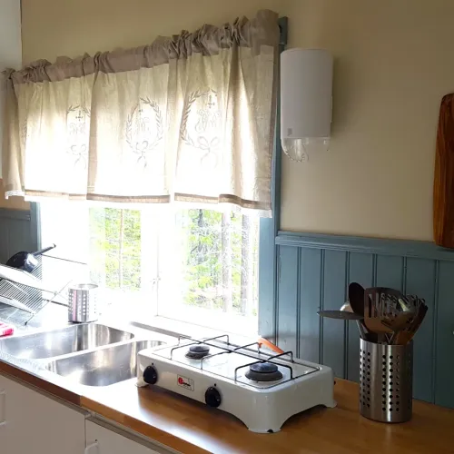 Kök med gasolkokplatta och dekorerad gardin